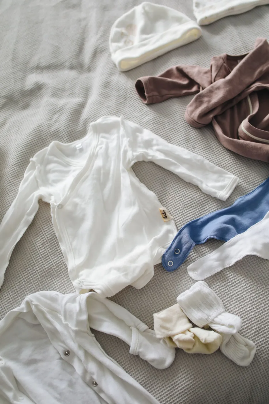 Vêtements de bébé préparés sur un lit