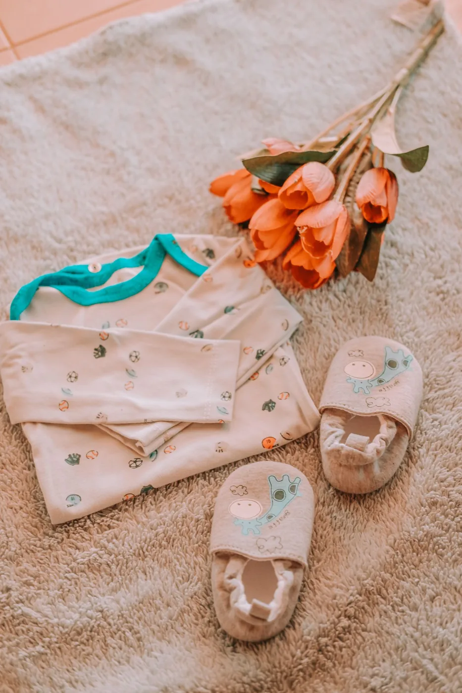 Petits vêtements roses et tulipes disposés à plat